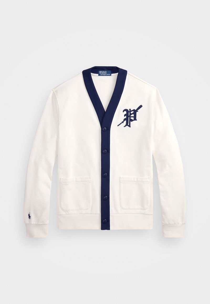 Hvid cardigan med marineblå detaljer, v-hals, knaplukning, to frontlommer, og en stor marineblå "P"-logo på venstre side.