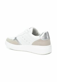Zapatilla blanca con parte superior de cuero liso, acentos de ante gris, tacón metálico plateado y detalles perforados en la puntera.