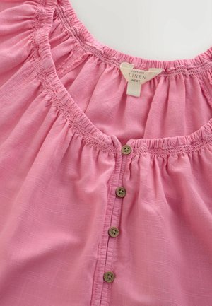 Rózsaszín lenvászon felső, ráncolt nyakkivágással és gombos záródással. Négy fa gombbal az elején, puha, texturált anyagból készült.