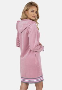 Abito a felpa rosa con cappuccio e vestibilità rilassata, caratterizzato da dettagli grigi e strisce all'orlo e due tasche laterali. Texture liscia.