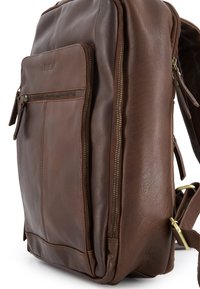 Brun læderrygsæk med en glat tekstur, lynlåslomme foran og justerbar skulderrem for ekstra bekvemmelighed.