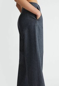 Wide-leg trousers in dark denim, featuring a high waist, side pockets, and clean lines. Smooth texture with subtle stitching detail.