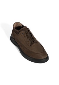 Bruine leren sneaker met een ronde neus, gestructureerde bovenkant en zwarte rubberen zool. Vetersluiting met metalen oogjes en een gewatteerde kraag.