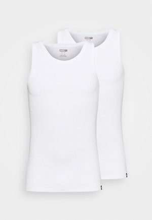 Two white tank tops made of cotton, featuring crew necks and no sleeves. Each top has a small logo at the hem. Smooth texture.