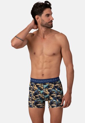 Blauwe boxer briefs met een tropisch bladenpatroon in groen, geel en blauw op een donkere achtergrond. Gemaakt van rekbaar materiaal.