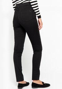 Svarta skinny jeans med hög midja, med en enkel design, två bakfickor och subtila dekorativa sömmar.
