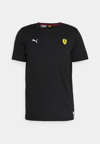 Černé bavlněné tričko s krátkým rukávem, na levé části hrudi s bílým logem Puma a žlutým emblémem Ferrari. Kulatý výstřih.