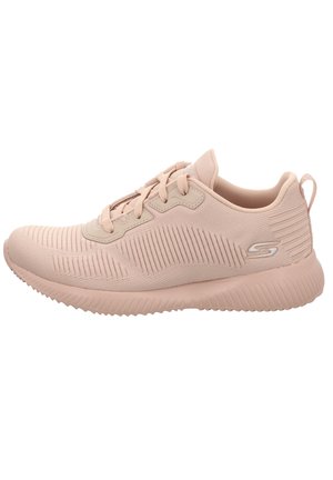 Zapatilla deportiva de color rosa claro con una parte superior de tejido transpirable, patrón texturizado, cordones planos y una suela acolchada. Presenta un logo en el lateral.