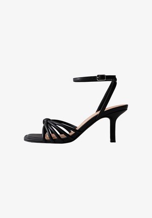 Sandalia negra de tiras con punta cuadrada, correa ajustable en el tobillo y tacón delgado. Fabricada con material suave con acentos de diseño fruncido.