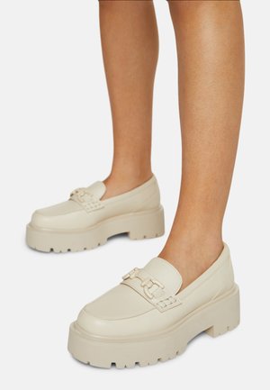 Crème leren platform schoenen met een chunky zool, voorzien van een decoratieve strap en metallic accenten. Glad textuur en rond toelont ontwerp.