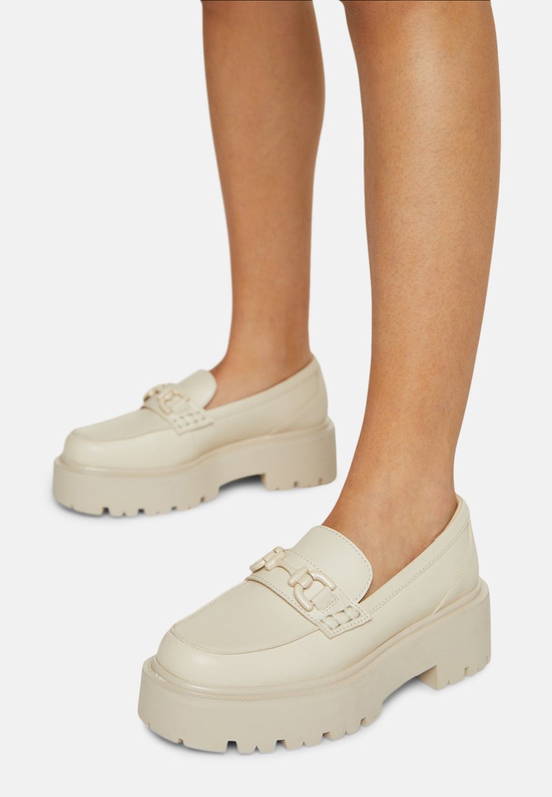Crème leren platform schoenen met een chunky zool, voorzien van een decoratieve strap en metallic accenten. Glad textuur en rond toelont ontwerp.