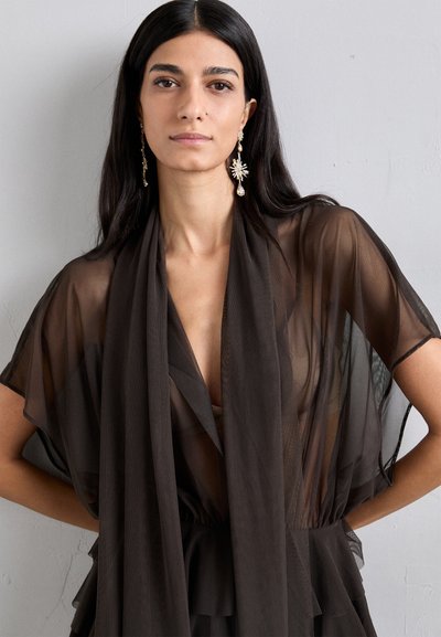 Črn prosojni kimono z raznobarvnimi rokavi, ki ima globok V izrez in zbrano pas. Okrašen z dolgimi, okrašenimi uhani.
