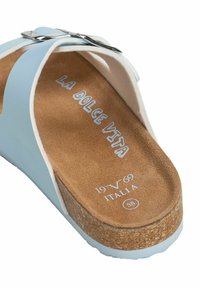 Blauwe sandaal met kurken voetbed, witte accenten en zilveren gesp. Binnenin staat de 'La Dolce Vita' branding en schoenmaat 38.