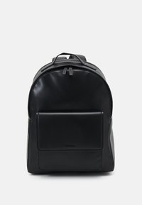 Schwarzer Leder-Rucksack mit runder Form, Vordertasche, doppelten Rei�ßverschlusszips und Logodetail am Boden. Glatte Textur.