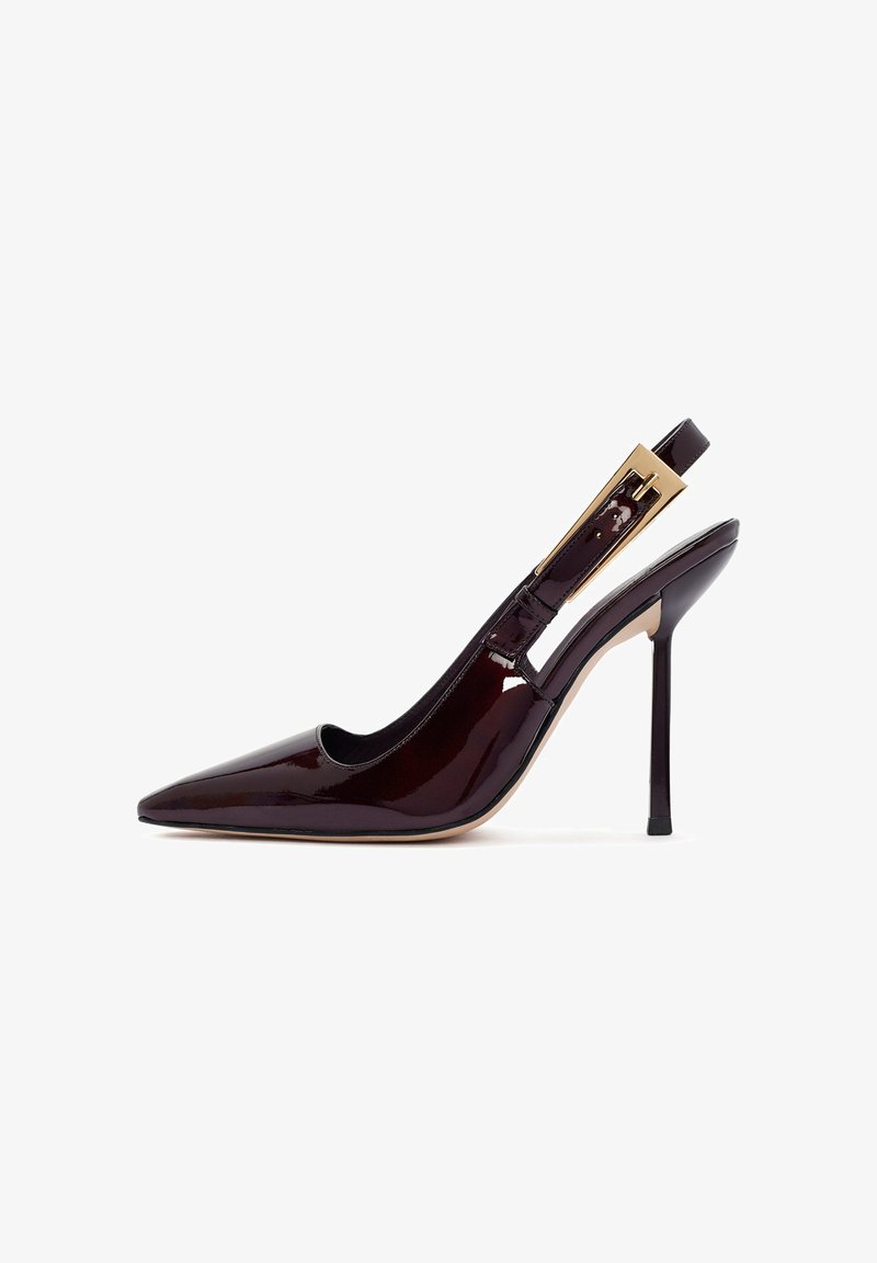 Slingback hoge hak schoen in donker bordeaux patentleer, puntige neus, open zijkanten, met een goudkleurige gespaccent op de band.