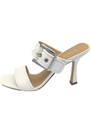 Sandalia de tacón alto de cuero blanco con dos correas anchas y una hebilla plateada. Diseño de punta abierta, suela contorneada y un tacón delgado estilo stiletto.