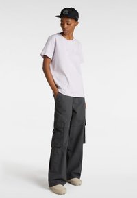 Lila katoenen t-shirt met geborduurd logo, gecombineerd met donkergrijze cargobroek met meerdere zakken en een losse pasvorm. Beige schoenen maken de look compleet.