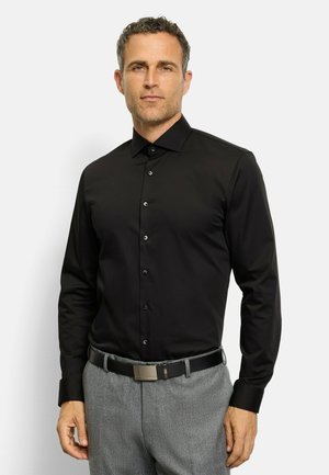 Schwarzes Hemd mit Button-down-Kragen und langen Ärmeln, mit glatter Textur und subtiler Oberfläche, kombiniert mit grauen Hosen und einem schwarzen Gürtel.