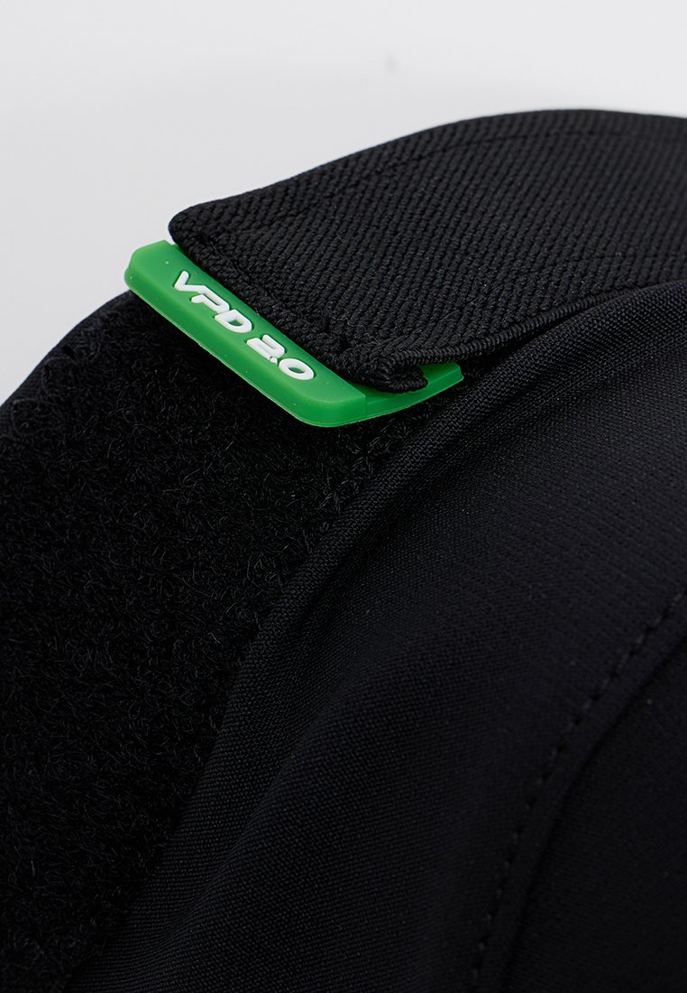 Schwarzes Textilprodukt mit strukturierter Oberfläche, glattem Riemen und einem grünen Etikett, auf dem "VPD 2.0" deutlich sichtbar ist.