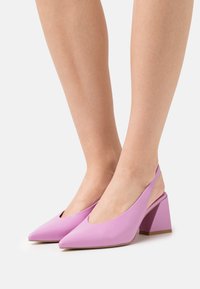 Lila slingbackklackar med spetsig tå, tillverkade av slätt material, med en kraftig klack och en öppen baksidesdesign.