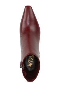 Stivale in pelle bordeaux con punta appuntita, texture liscia, zip laterale e logo dorato sulla soletta, progettato per una vestibilità avvolgente.