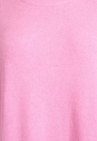 Maglione in cotone rosa a girocollo, morbido al tatto e con una finitura liscia, che mette in evidenza il colore uniforme e il design minimale.