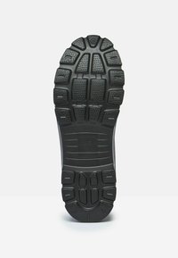 Čierna gumová podrážka s viacsmerným dezénom a textúrovanými úchopmi. Spevnená päta a plochá predná časť chodidla pre stabilitu.