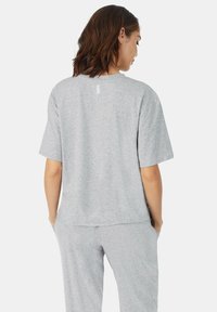 Grijze katoen T-shirt met korte mouwen, ontspannen pasvorm en een klein logo-detail op de achterkant van de nek. In combinatie met bijpassende grijze broek.