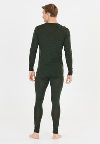 Mörkgrön långärmad thermotopp och matchande leggings, tillverkade av ett strukturerat tyg, åtsittande passform med långa ärmar och skräddarsydda nederkanter.