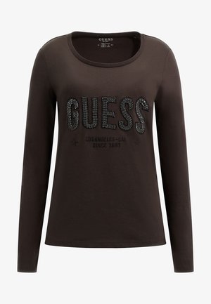 Camisa de manga larga color marrón oscuro hecha de algodón. Cuenta con un escote redondeado y el logo "GUESS" en pedrería negra brillante. Estrellas impresas debajo del logo.