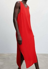 Robe sans manches rouge à coupe droite, avec une fente latérale et un tissu léger. Texture lisse, design minimaliste, avec une légère silhouette en A.