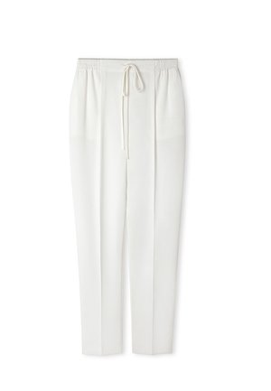 Białe spodnie o prostych nogawkach z elastycznym pasem i sznurkiem do ściągania, z przodu z zakładkami i gładką fakturą tkaniny.