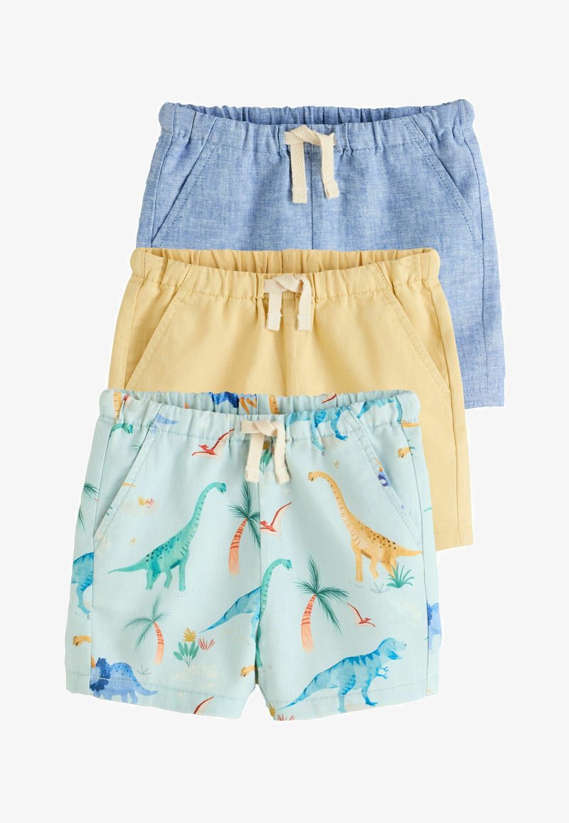 Trois shorts pour enfants empilés, comprenant un en lin bleu, un en coton jaune et un bleu clair avec des imprimés colorés de dinosaures et de palmiers.