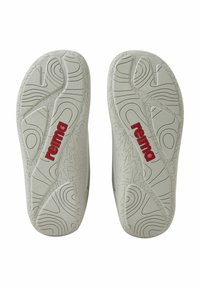 Szare gumowe podeszwy butów z teksturowanymi wzorami i czerwonym logo "reima", z falistym wzorem zapewniającym przyczepność.