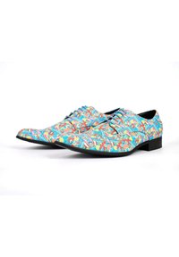 Chaussures habillées à motifs avec un design floral multicolore sur un tissu lisse, dotées d'un bout pointu et d'une semelle en caoutchouc noire.