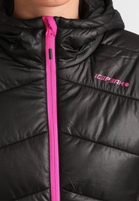 Černá prošívaná bunda s růžovým zipem a logem. Obsahuje kapuci a hladkou, lesklou texturu. Vertikální švy vytvářejí polstrovaný design.