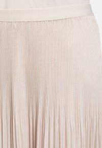 Faltenrock in hellbeige, aus strukturiertem Stoff mit vertikalen Streifen und einem glatten, elastischen Bund für einen bequemen Sitz.