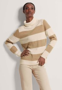 Cremfarbener und braun gestreifter Pullover mit hohem, geripptem Kragen, gerippten Bündchen und lässiger Passform. Hergestellt aus einem weichen, strukturierten Material.