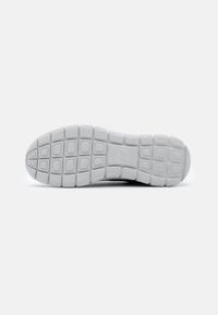 Shoe sole with a white, textured rubber surface, featuring a grid pattern for traction and support, designed for comfort and durability.