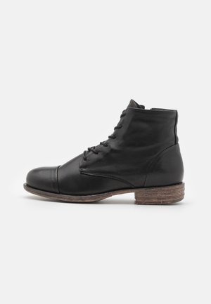 Botas de tobillo de cuero negro con punta redondeada, parte delantera con cordones y un tacón bajo apilado. Presentan una textura lisa y detalles de costura mínimos.