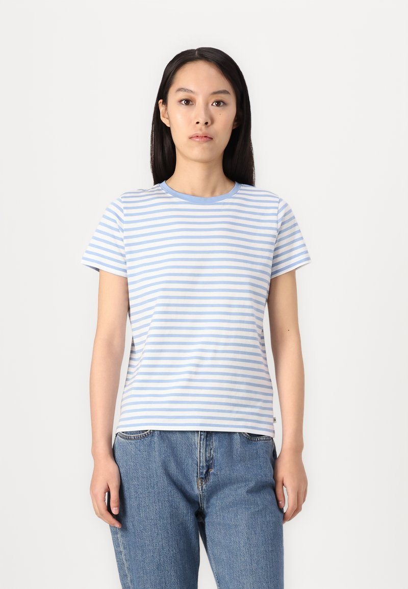 Kottong T-skjorte med lyseblå og hvite horisontale striper, rund hals, korte ermer og rett passform, kombinert med løse blå jeans.