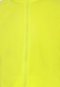 Fluo geel jack met een gladde, zachte textuur, voorzien van een centrale ritssluiting en een minimalistisch ontwerp.