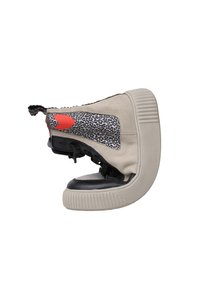 Sneaker con tomaia in suede beige, suola in gomma nera, dettagli leopardati sui lati e un cuore rosso sul retro. Design alta.