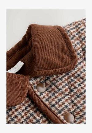 Nertinis švarkas su rudais švelniais kailio apykaklėmis, su šuniuko dantų raštu smėlio, rudos ir pilkos spalvų, ir rudais mygtukais su užsegimu.