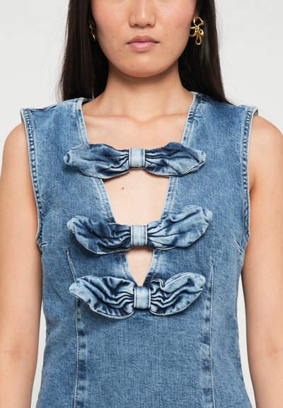 Denim ilmanhiha dressi, jossa on kolme erikokoista nauhakoristetta syvässä V-kauluksessa, vaaleansinisessä haalistuneessa pesussa ja teksturoidussa pinnassa.