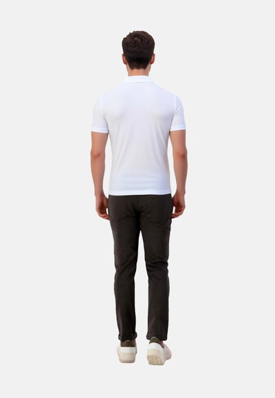Weißes Polohemd mit kurzen Ärmeln, kombiniert mit dunkelgrauen Slim-Fit-Hosen und weißen Turnschuhen. Schlichtes Design, glatter Stoff und maßgeschneiderte Passform.