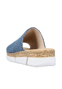 Chaussure slip-on en denim bleu avec une semelle intermédiaire en liège et une semelle extérieure en caoutchouc blanc. Dotée d'un cuir supérieur texturé et d'un design de talon ouvert pour la respirabilité.