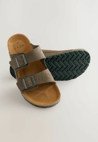 Sandales en daim marron avec deux boucles argentées réglables, une semelle intérieure contournée et une semelle extérieure en caoutchouc noir texturé présentant un motif en zigzag.