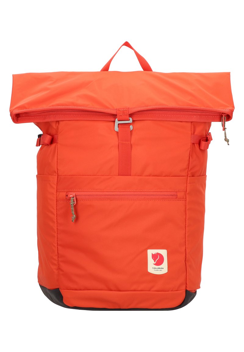 Sac à dos orange à rabat supérieur avec une poche zippée et des bretelles ajustables. Fabriqué en tissu durable avec un patch logo et une base noire.