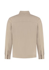 Beige overhemd met lange mouwen, een gestructureerde kraag, knoopmanchetten en een gladde textuur. Heeft een schouderpas met naaddetails op de rug.
